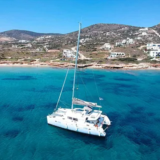 Λευκό καταμαράν σε γαλαζοπράσινα νερά — κρουαζιέρα και εκδρομές με σκάφος